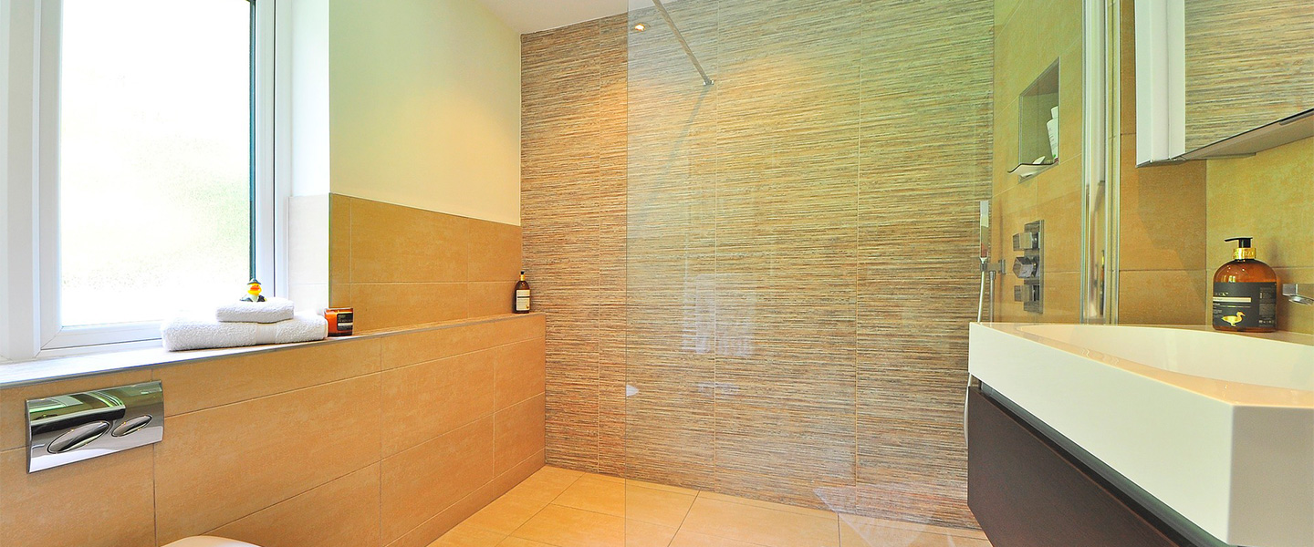 Mujer haciendo limpieza de baño en casa, pared de azulejos de